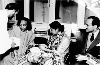 Swami Kriyananda reicht Guruji eine Schachtel mit Süßigkeiten, die für den Botschafter Binay R. Sen. Seen gedacht sind.
oben: neben Paramhansa Yogananda ist Mrs. Sen.